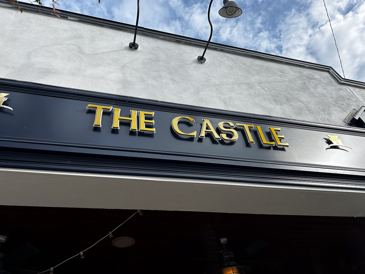the castle gold sign on a dark building